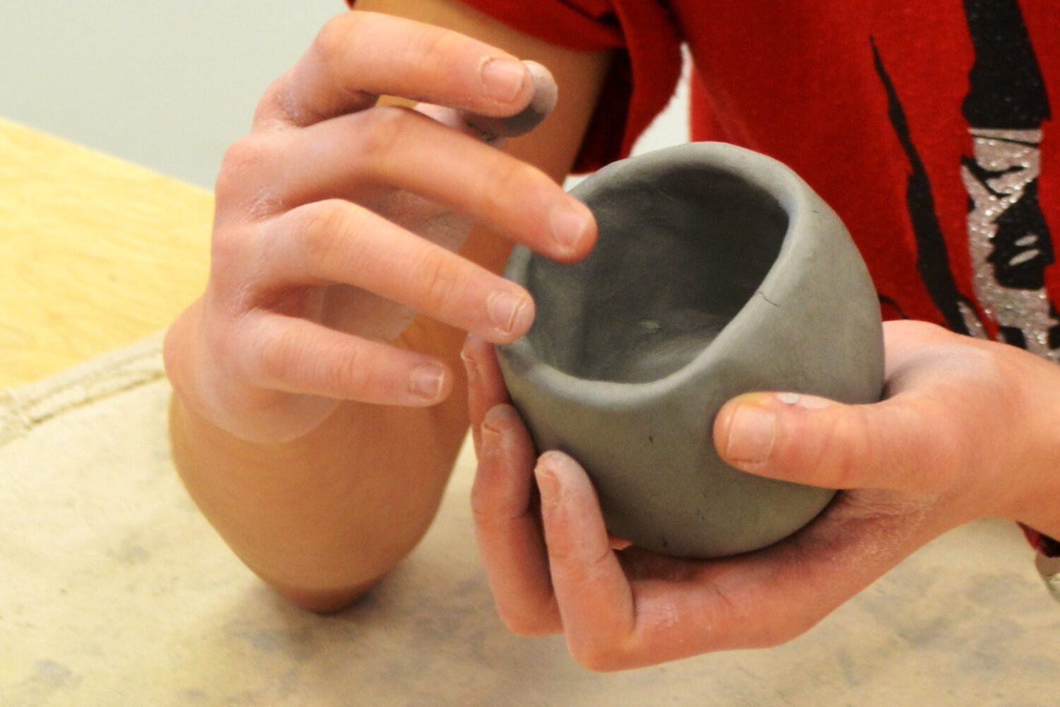 person holding ceramic pot